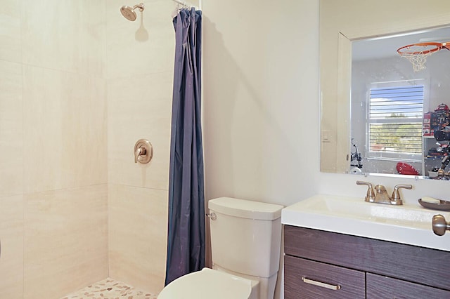 bathroom featuring vanity, toilet, and tiled shower