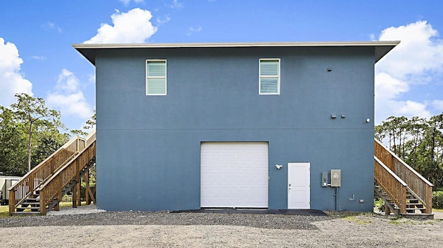 back of house featuring stairway and an attached garage