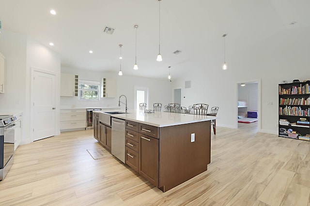 13327 Marcella Blvd, Loxahatchee Groves, FL 33470 - kitchen featuring wine cooler, stainless steel appliances, dark brown cabinets, visible vents, and light countertops
