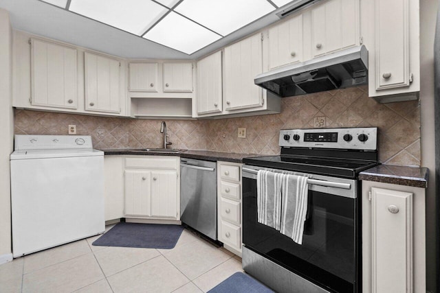 kitchen with light tile patterned floors, washer / dryer, a sink, under cabinet range hood, and appliances with stainless steel finishes