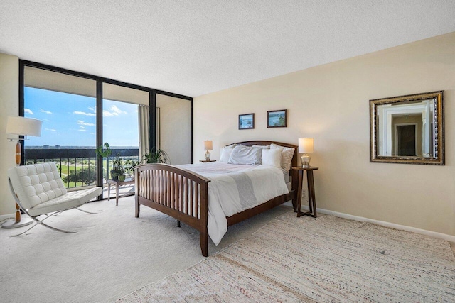 bedroom featuring expansive windows, light carpet, baseboards, and access to exterior