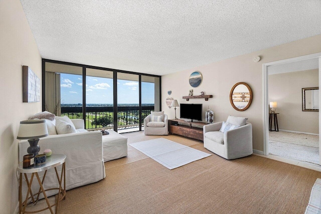 living room featuring floor to ceiling windows, carpet flooring, baseboards, and a textured ceiling