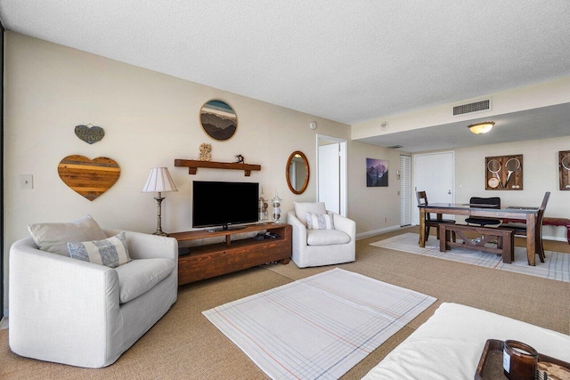 living area featuring visible vents, light colored carpet, a textured ceiling, and baseboards