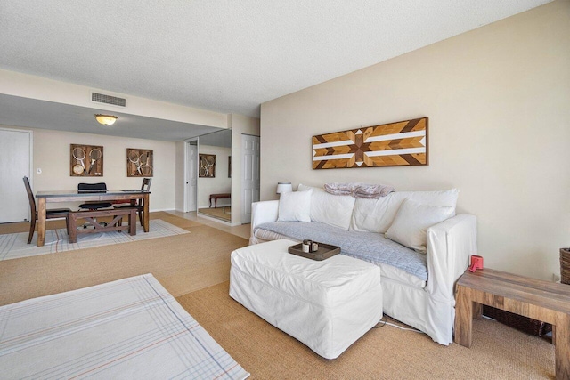 living room with visible vents and a textured ceiling