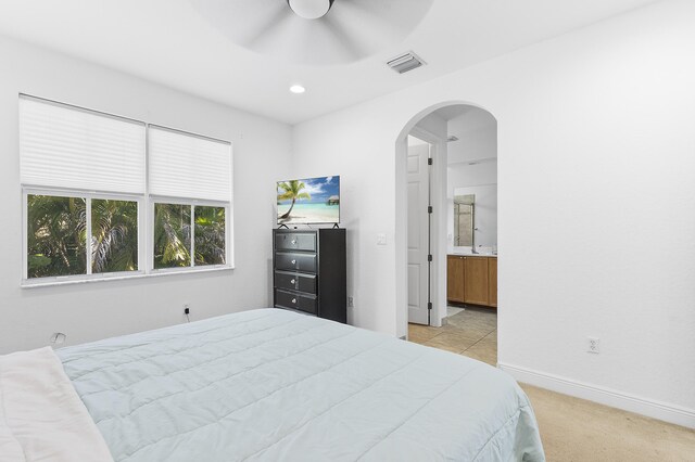 bedroom featuring visible vents, light carpet, recessed lighting, arched walkways, and baseboards