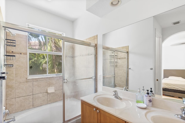 ensuite bathroom with a sink, connected bathroom, visible vents, and double vanity