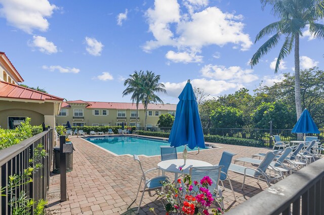 community pool featuring a patio and fence