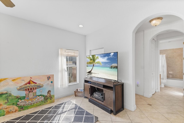 living room with baseboards, arched walkways, and light tile patterned flooring