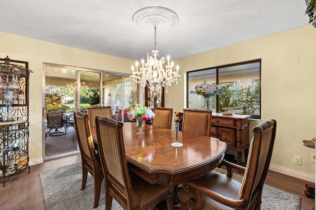 dining area with wood finished floors, baseboards, and a chandelier