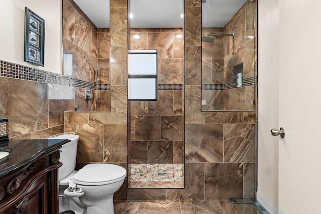 bathroom with vanity, tile walls, toilet, and walk in shower