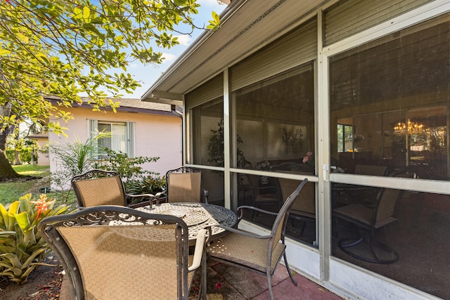 view of patio with outdoor dining area and a sunroom