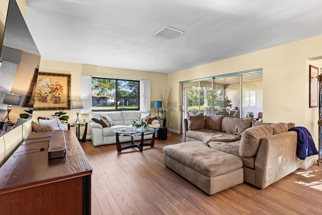 living room featuring plenty of natural light, visible vents, and wood finished floors