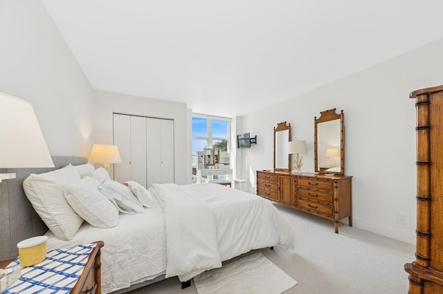 carpeted bedroom with baseboards and a closet