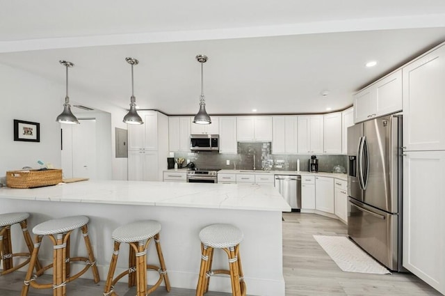 kitchen featuring tasteful backsplash, white cabinetry, and stainless steel appliances