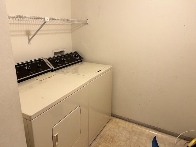 washroom with laundry area, separate washer and dryer, baseboards, and light floors