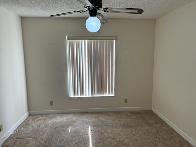 unfurnished room with ceiling fan, carpet, baseboards, and a textured ceiling