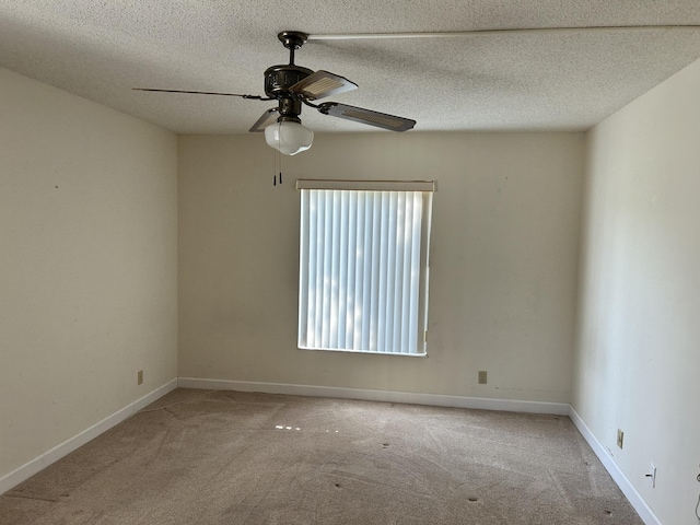 unfurnished room with baseboards, carpet, ceiling fan, and a textured ceiling