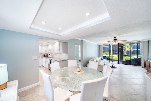 dining area with baseboards, recessed lighting, crown molding, a textured ceiling, and a raised ceiling