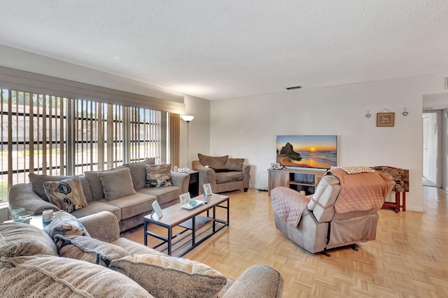 living room with visible vents and a textured ceiling