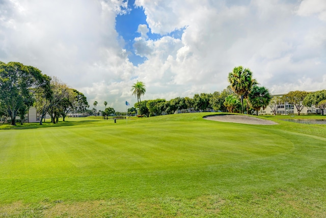 view of home's community featuring a lawn and view of golf course