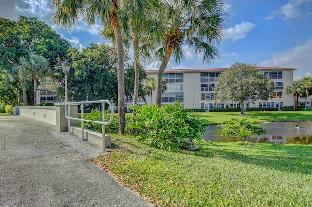 view of property's community featuring a gate, a yard, and a water view