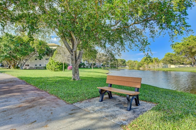 view of home's community with a lawn and a water view