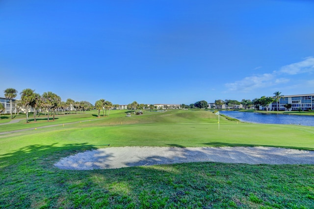 view of home's community with a yard, a water view, and view of golf course