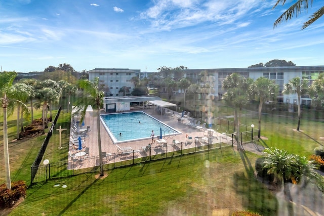 community pool featuring a patio, fence, and a lawn