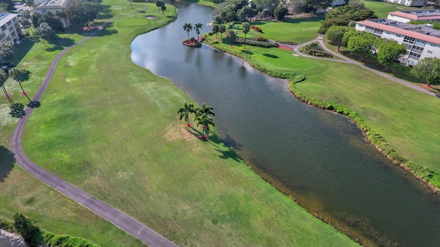 drone / aerial view with golf course view and a water view