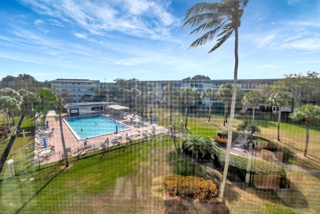 community pool featuring a yard and fence