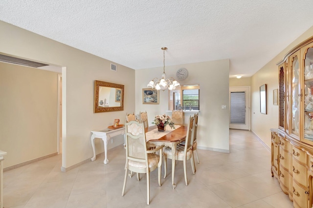 dining space featuring visible vents, a notable chandelier, light tile patterned flooring, and a textured ceiling