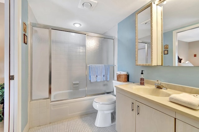 full bathroom featuring tile patterned flooring, toilet, vanity, and shower / bath combination with glass door