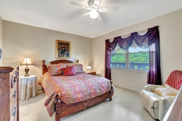 bedroom with ceiling fan, light tile patterned floors, baseboards, and a textured ceiling