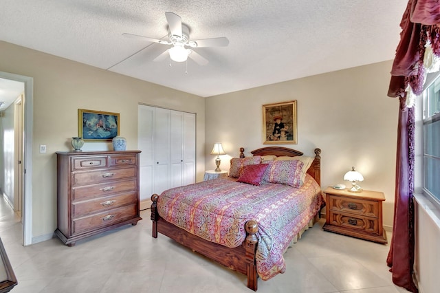 bedroom featuring ceiling fan, baseboards, a closet, and a textured ceiling