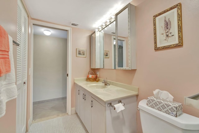 bathroom with tile patterned flooring, visible vents, toilet, and vanity