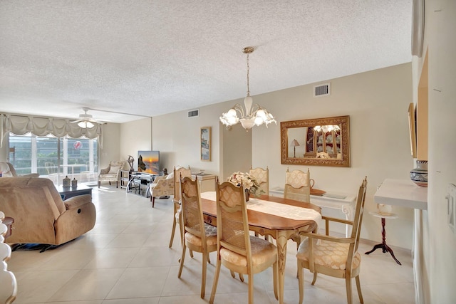 dining room with light tile patterned flooring, visible vents, and a textured ceiling