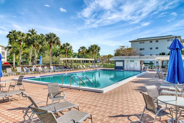 pool with a patio area and fence