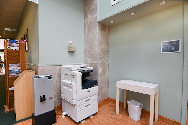 miscellaneous room with tile walls and light wood-style floors