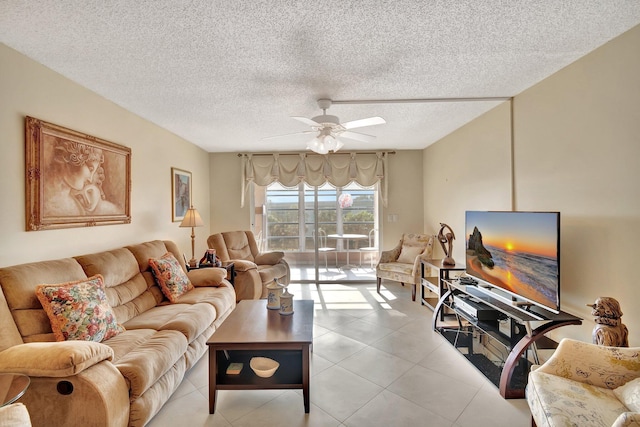 living room featuring ceiling fan, a textured ceiling, and light tile patterned flooring