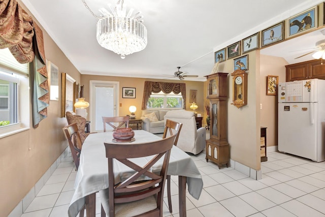 dining area featuring light tile patterned floors, ceiling fan with notable chandelier, and baseboards