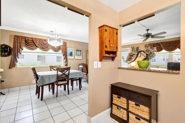 dining space featuring light tile patterned floors, ceiling fan with notable chandelier, and baseboards