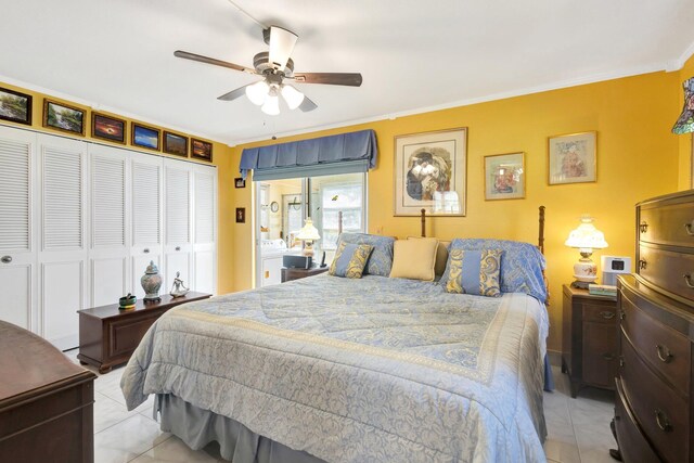 bedroom with light tile patterned floors, ceiling fan, a closet, and ornamental molding