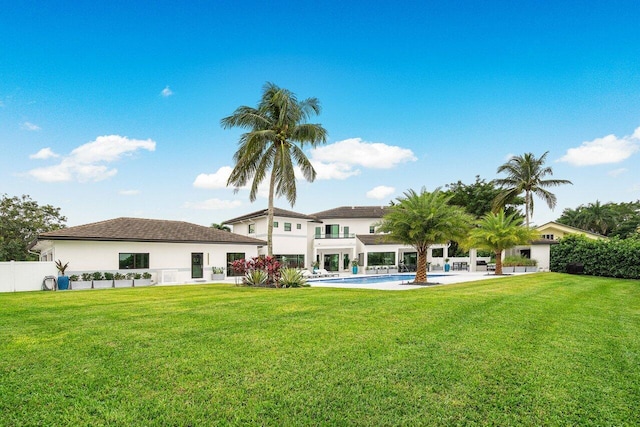 back of property featuring a patio, fence, a lawn, and an outdoor pool