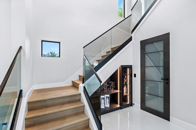 stairs with a high ceiling and baseboards