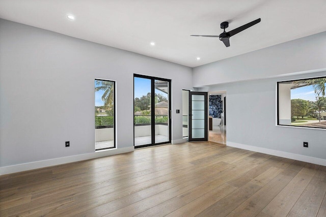 unfurnished room with hardwood / wood-style flooring, recessed lighting, and baseboards