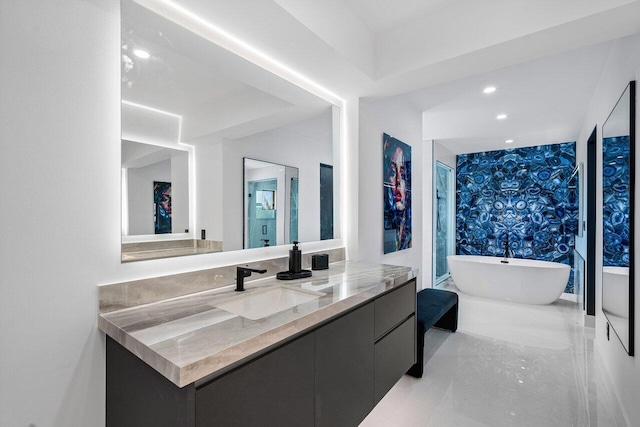 full bathroom with recessed lighting, vanity, and a freestanding tub