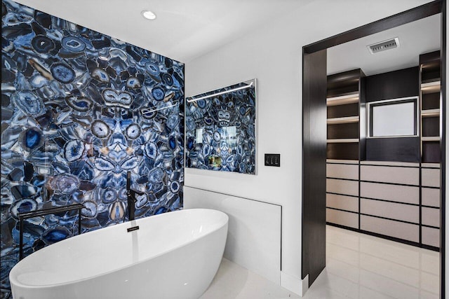 bathroom with visible vents and a freestanding tub