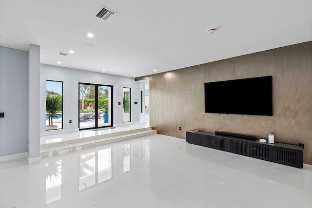 living area featuring an accent wall, recessed lighting, visible vents, and marble finish floor