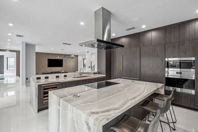 kitchen with beverage cooler, visible vents, a spacious island, black electric stovetop, and island range hood