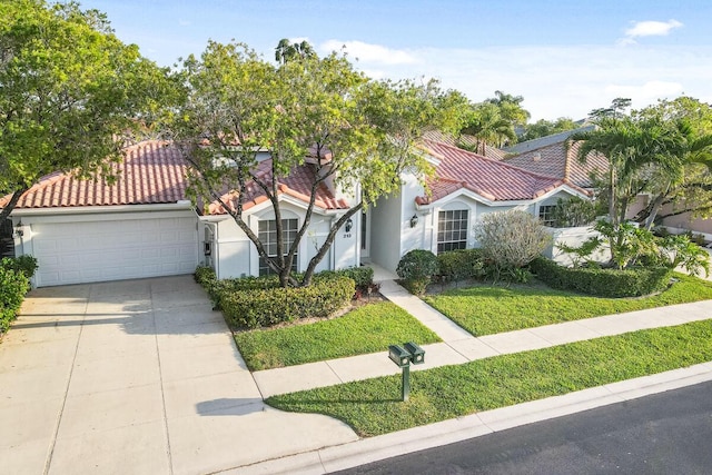 mediterranean / spanish-style home with a front lawn, concrete driveway, a tile roof, stucco siding, and a garage